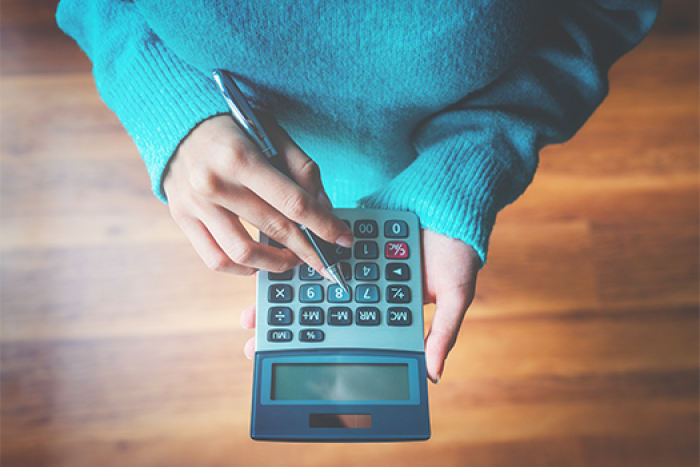 womans hands using calculator