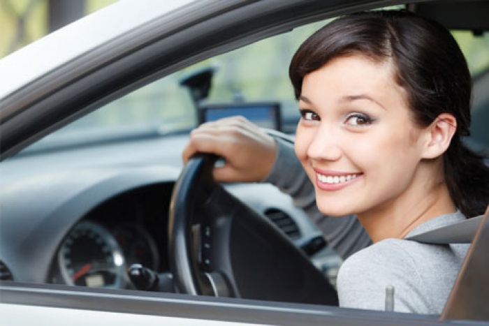 teenage girl looking out car window from drivers seat