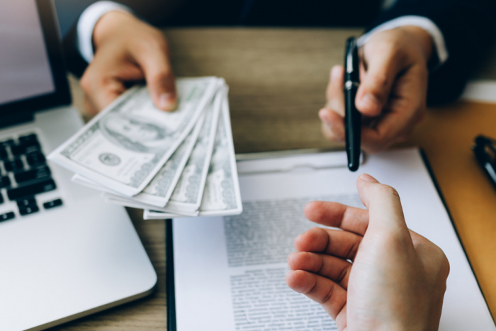 Man handing over money and pen to sign contract