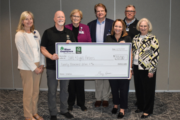 holding large donation check
