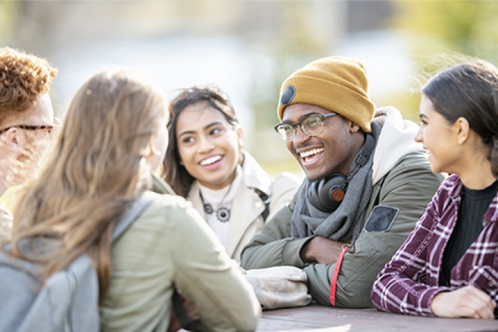 Group of people laughing around a table outdoors